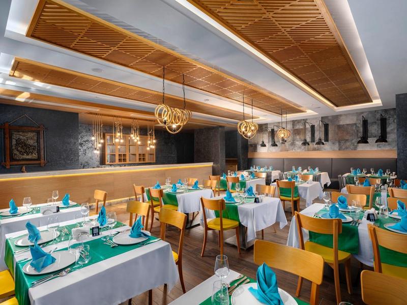 A cozy, well-lit restaurant with set tables and blue napkins.