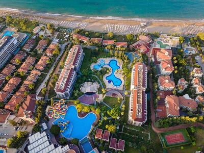 Widok z lotu ptaka ośrodka z basenami, budynkami i plażą w tle