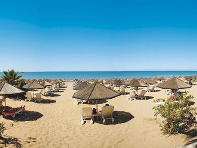 Playa con sombrillas y tumbonas bajo un cielo azul claro junto al mar