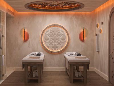 Sala de bienestar elegante con dos camillas de masaje y elementos cálidos de madera e iluminación.