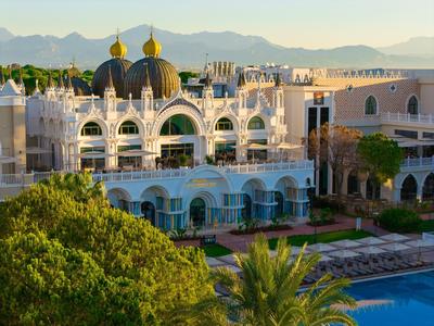 Hotel lujoso con arquitectura única, cúpulas doradas y una gran piscina en primer plano.
