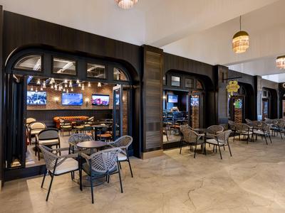 Nowoczesne wnętrze hotelu z miejscami do siedzenia i barem pod ciepłym oświetleniem.