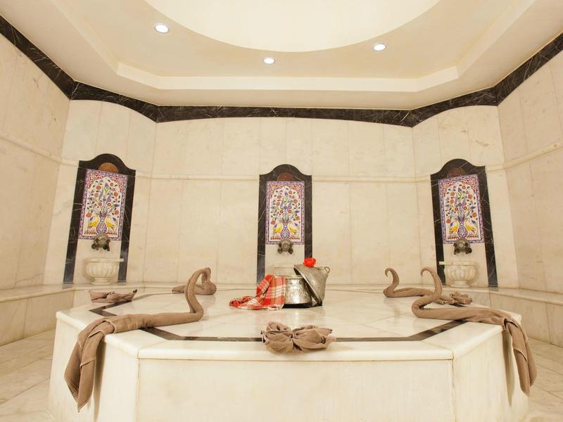 Lujosa sala tradicional de hammam con nichos decorativos y ambiente acogedor.