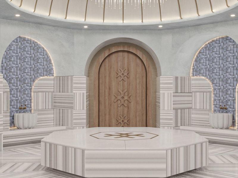 Hamam turco moderno con mosaicos y plataforma de piedra central en una sala circular.
