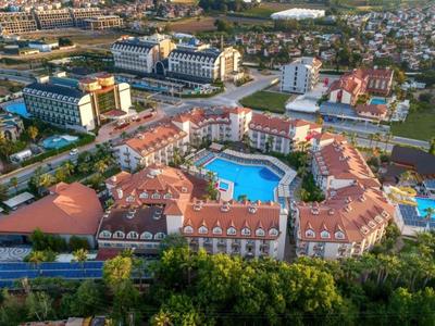 Großes Hotelresort mit mehreren Gebäuden, Pools und viel Grün in einer Stadtlandschaft.