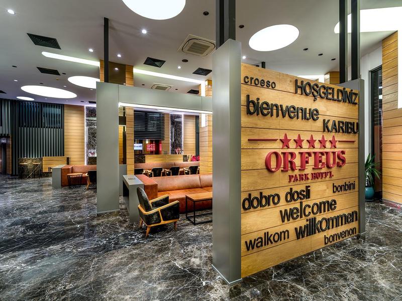 Moderna recepción de hotel con pared de bienvenida, asientos y suelo de mármol