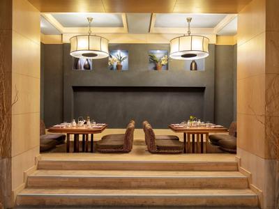 Sala da pranzo elegante con lampade a sospensione moderne e panchine nell'area d'attesa.