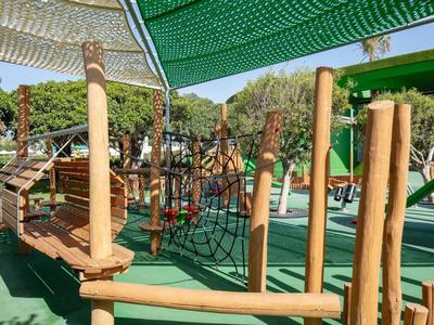 Parco giochi moderno con strutture per arrampicata e reti sotto coperture ombreggianti.