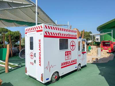 Parco giochi con mini ambulanze giocattolo sotto un cielo sereno.