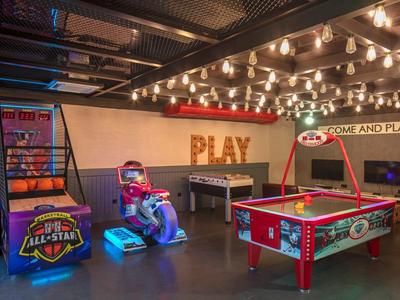 Una sala giochi con hockey su aria, un gioco di basket e piccole macchine arcade da corsa.