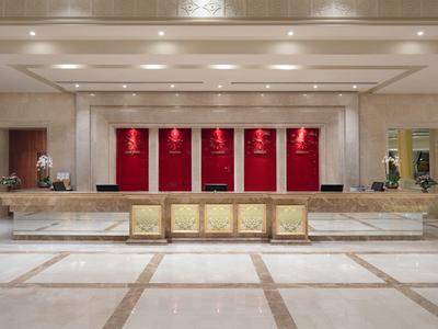 Reception elegante dell'hotel con grande bancone in marmo e sfondo rosso