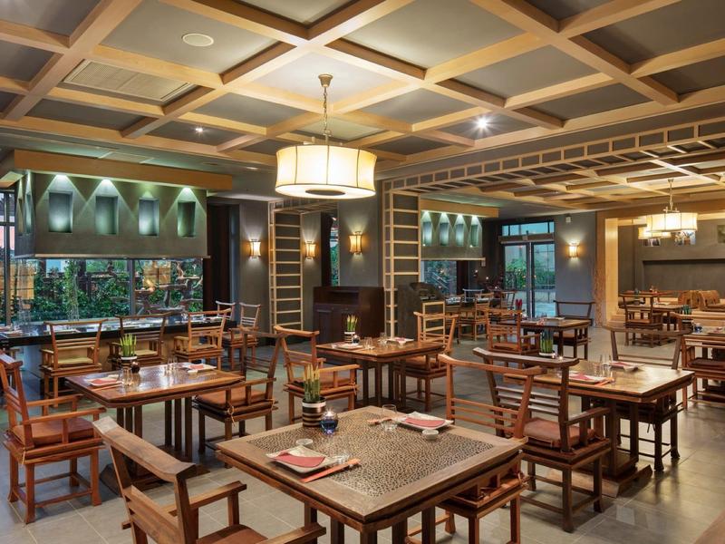 Ristorante elegante dell'hotel con tavoli in legno, sedie e atmosfera calda.