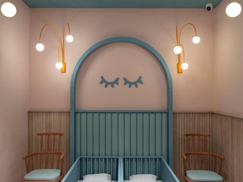 Lettino per bambini accogliente con struttura blu e decorazioni in una stanza elegante.