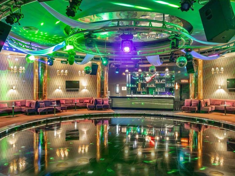 Disco moderna con pista da ballo circolare e illuminazione colorata.