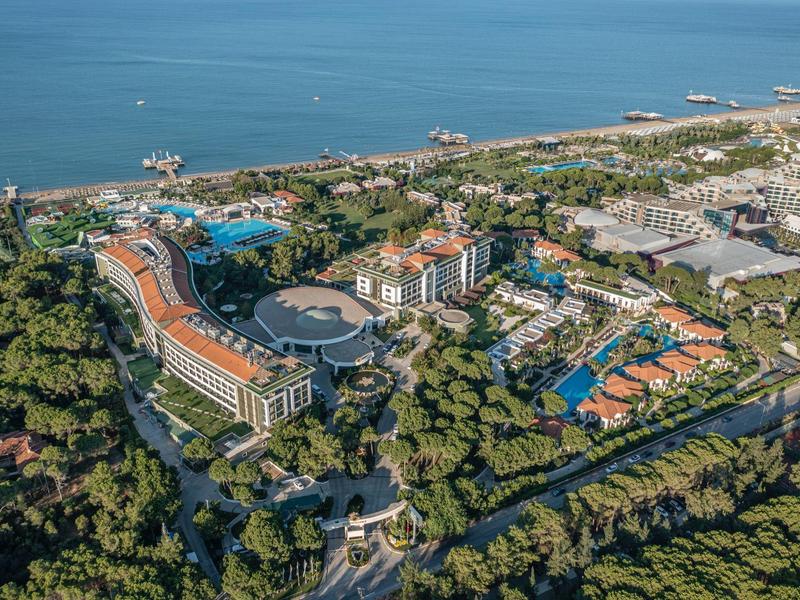 Veduta aerea di un grande hotel con piscine in una zona costiera verde