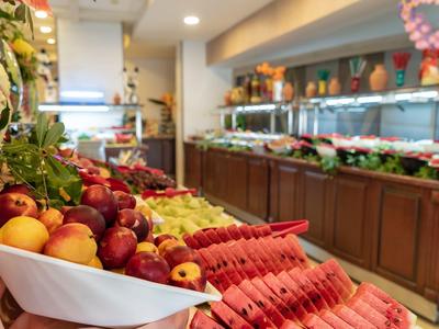 Bunte Obst- und Gemüsestände mit Wassermelone, Äpfeln und Trauben in einem Markt.