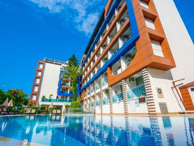 Modern hotelgebouw met groot zwembad en blauwe lucht