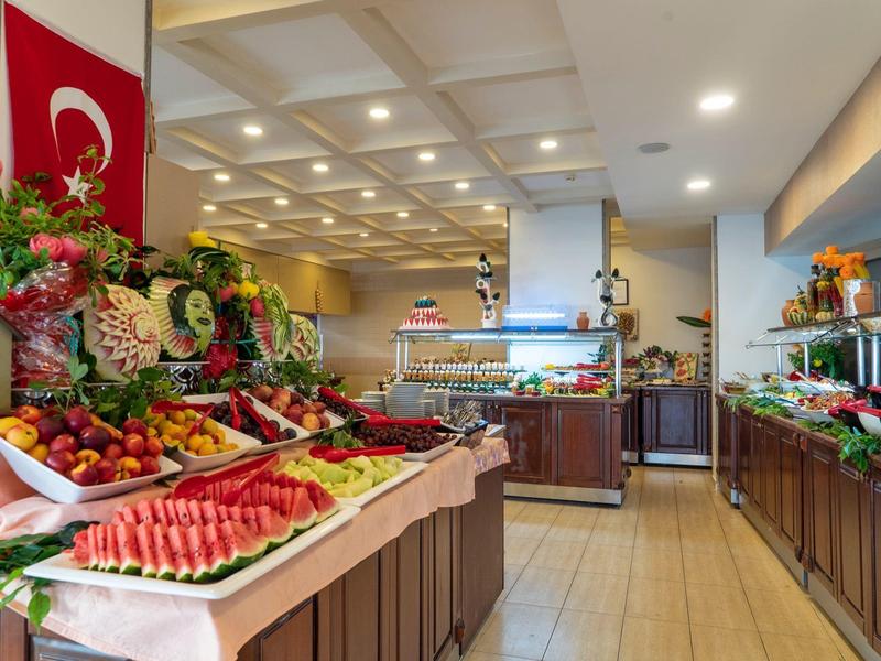 Buffet mit frischem Obst und Gemüse, türkische Flagge, helles, einladendes Restaurantinterieur.