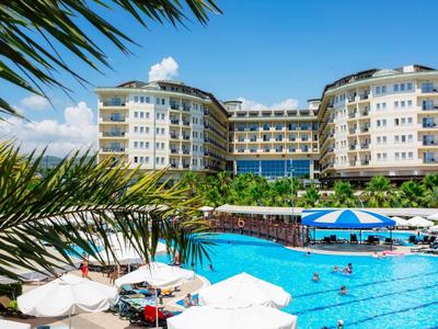 Moderní hotel s velkým venkovním bazénem a slunečníky za slunečného dne