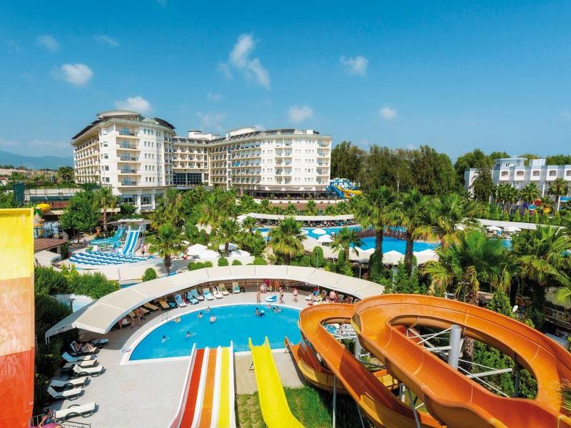 Velký hotel s několika vodními skluzavkami a bazénem pod modrou oblohou.