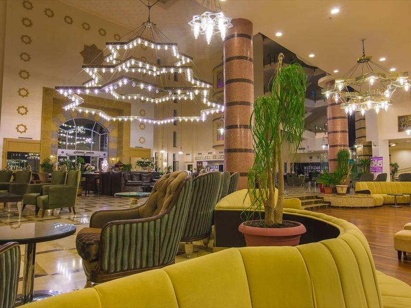 Luxusní hotelová hala s elegantním posezením a dekorativním osvětlením.