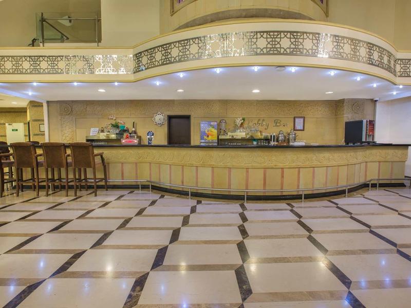 Prostorná hotelová hala s jasnou dlažbou a dlouhou recepcí