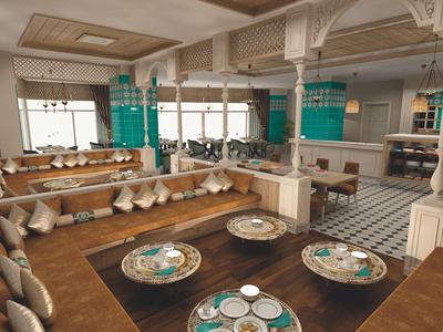 Großes Restaurant mit Holzmöbeln, Teppichen, vielen Sitzkissen und runden Tischen mit Geschirr.