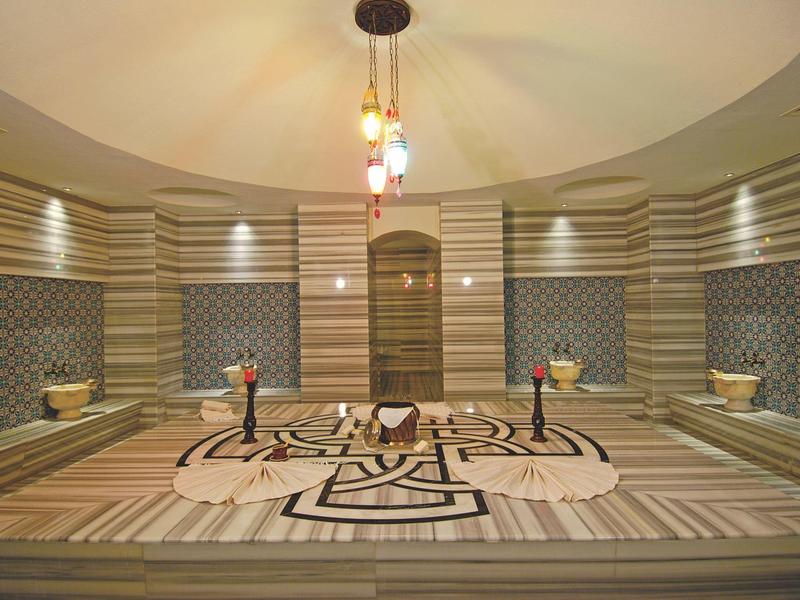 Elegante Turkse badhuis met ingewikkelde tegelpatronen en zachte verlichting.