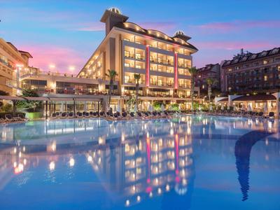 Modernes Hotelgebäude mit beleuchtetem Außenpool bei Dämmerung