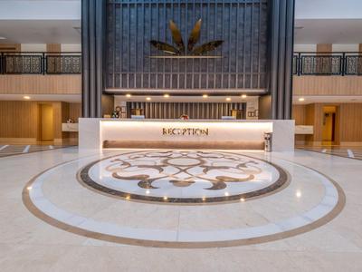 Gran recepción de hotel con mostrador elegante y suelo de mármol decorativo.