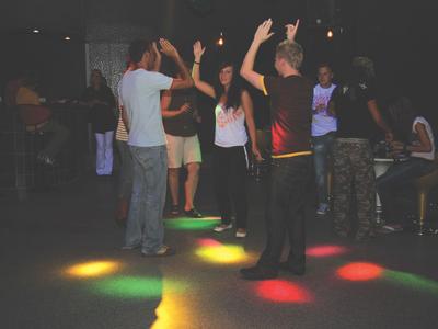 Deux toboggans aquatiques, un jaune et un multicolore, mènent à une piscine entourée de verdure.