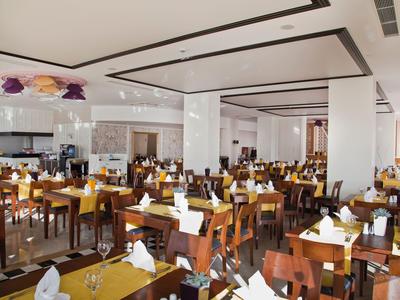 Restaurante grande y moderno con muchos asientos y luz cálida.