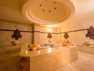 Eleganter Marmortisch und Sitze in einem luxuriösen, warm beleuchteten Hamam.