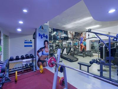 Moderne Fitnessstudio mit Gewichten, Geräten und Spiegeln in einem Hotel.