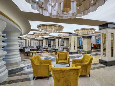Moderna hall dell'hotel con poltrone gialle e lampade a soffitto eleganti.