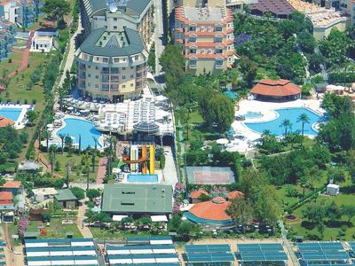 Vista aérea de un gran hotel con varias piscinas y acceso directo a una playa de arena.