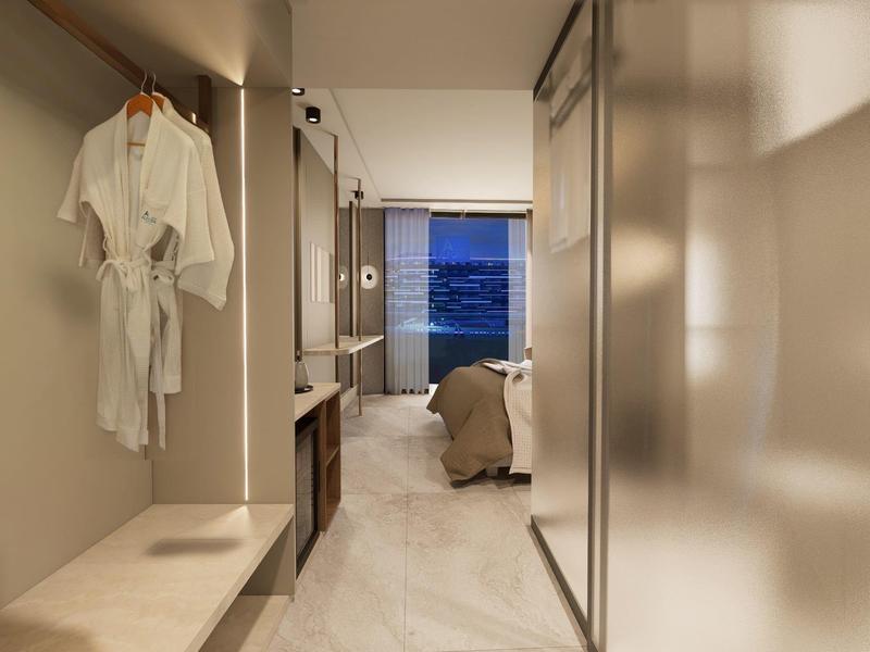 Pasillo de habitación de hotel con vista al mar, batas colgadas en la pared