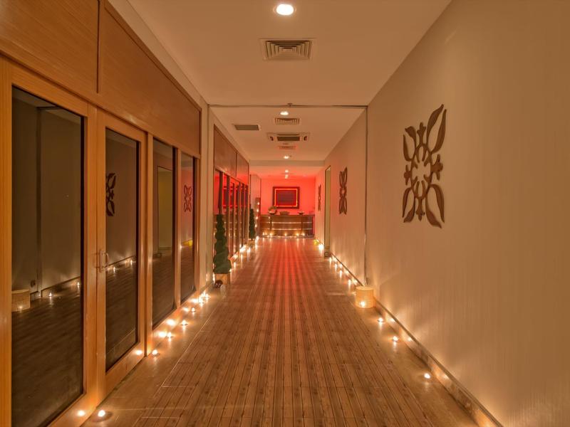Couloir d'hôtel éclairé avec lumière chaude et décorations murales simples.