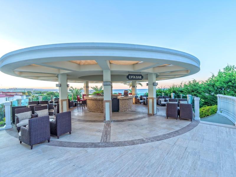 Espace bar extérieur rond et moderne avec des sièges et vue sur les environs.