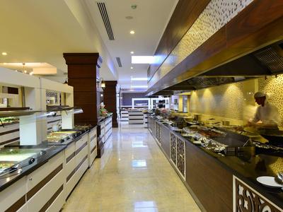 Dlouhá moderní bufetová oblast v restauraci nebo hotelu s osvětlením a stánky s jídlem.