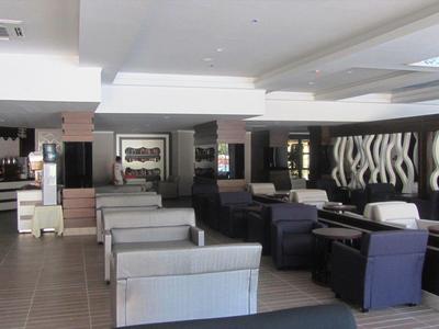 Moderní hotelová lounge se různými možnostmi sezení v neutrálních barvách.