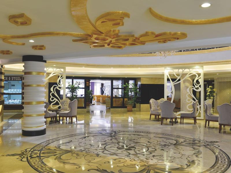 Elegatní hotelová hala s luxusní mozaikovou podlahou a moderními posezeními.