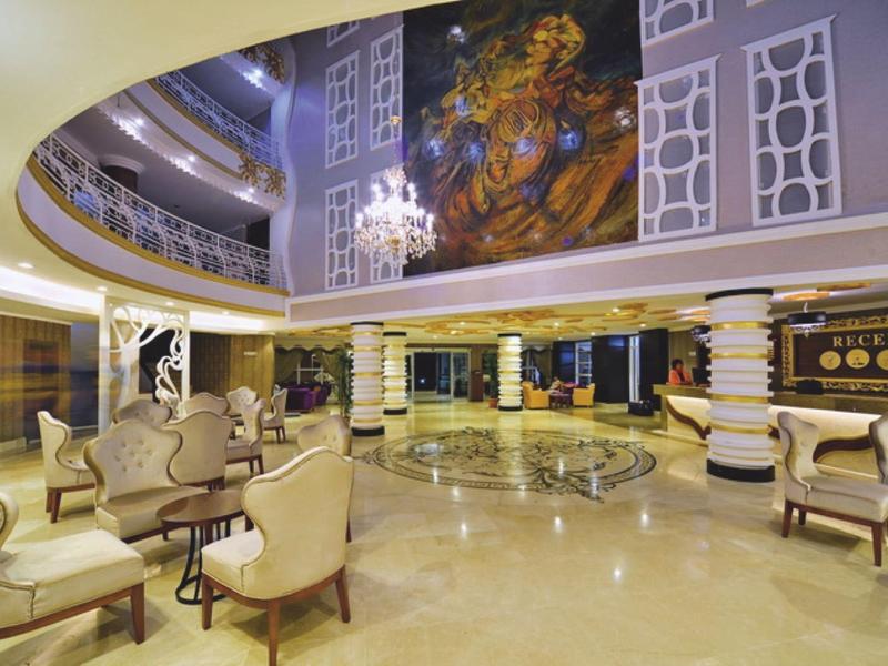 Prostorná, elegantní hotelová hala s pohodlnými křesly, mramorovou podlahou a dekorativním stropem.