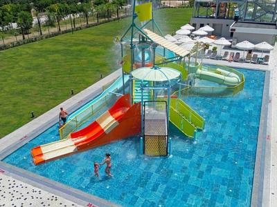 Vodní park s barevnými skluzavkami a bazénem v hotelu s výhledem na moře.