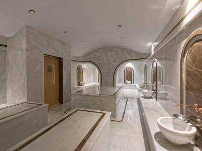 Moderner Wellnessbereich mit Marmorverkleidung und Waschbecken in einem Hotel.