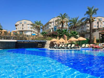 Großer Hotelpool mit Liegen und Sonnenschirmen unter klarem blauem Himmel