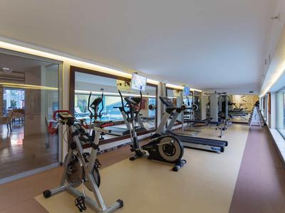 Moderne fitnessruimte met diverse trainingsapparatuur naast grote ramen