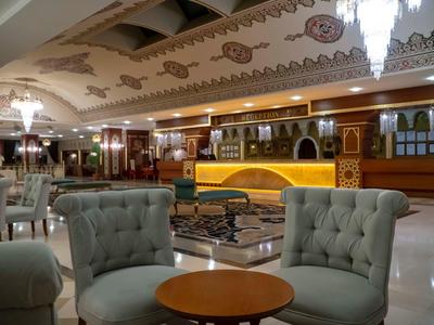 Luxuriöser Lobbybereich mit eleganten Sesseln, runden Tischen und opulenten Kronleuchtern.