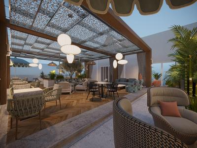 Área exterior moderna de un hotel con asientos acogedores bajo un techo de cristal.