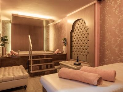 Sala de bienestar elegante y sencilla con mesa de masaje, toallas y luz cálida.